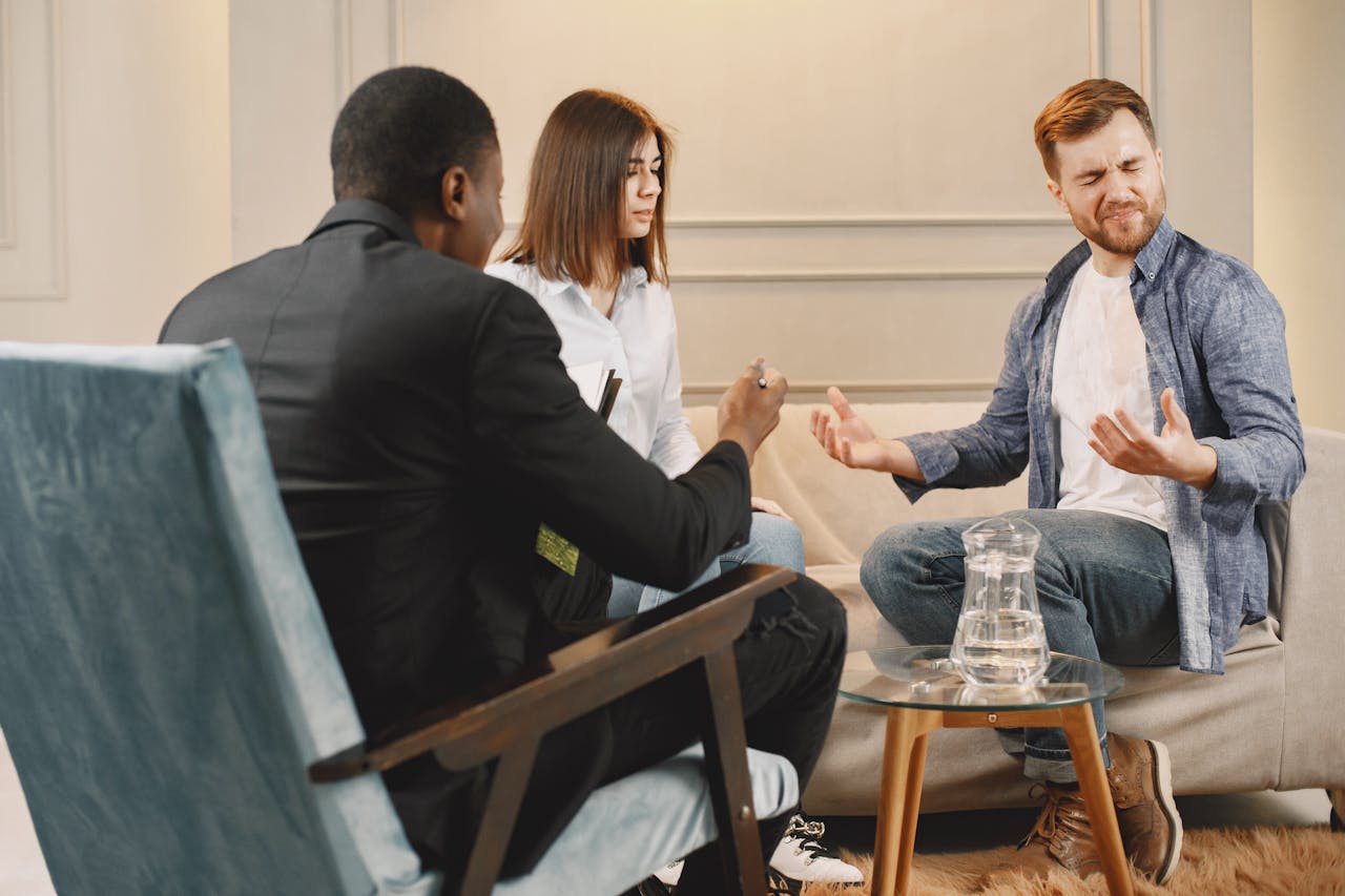 A diverse couple in a serious conversation with a lawyer during a meeting in an office setting.
